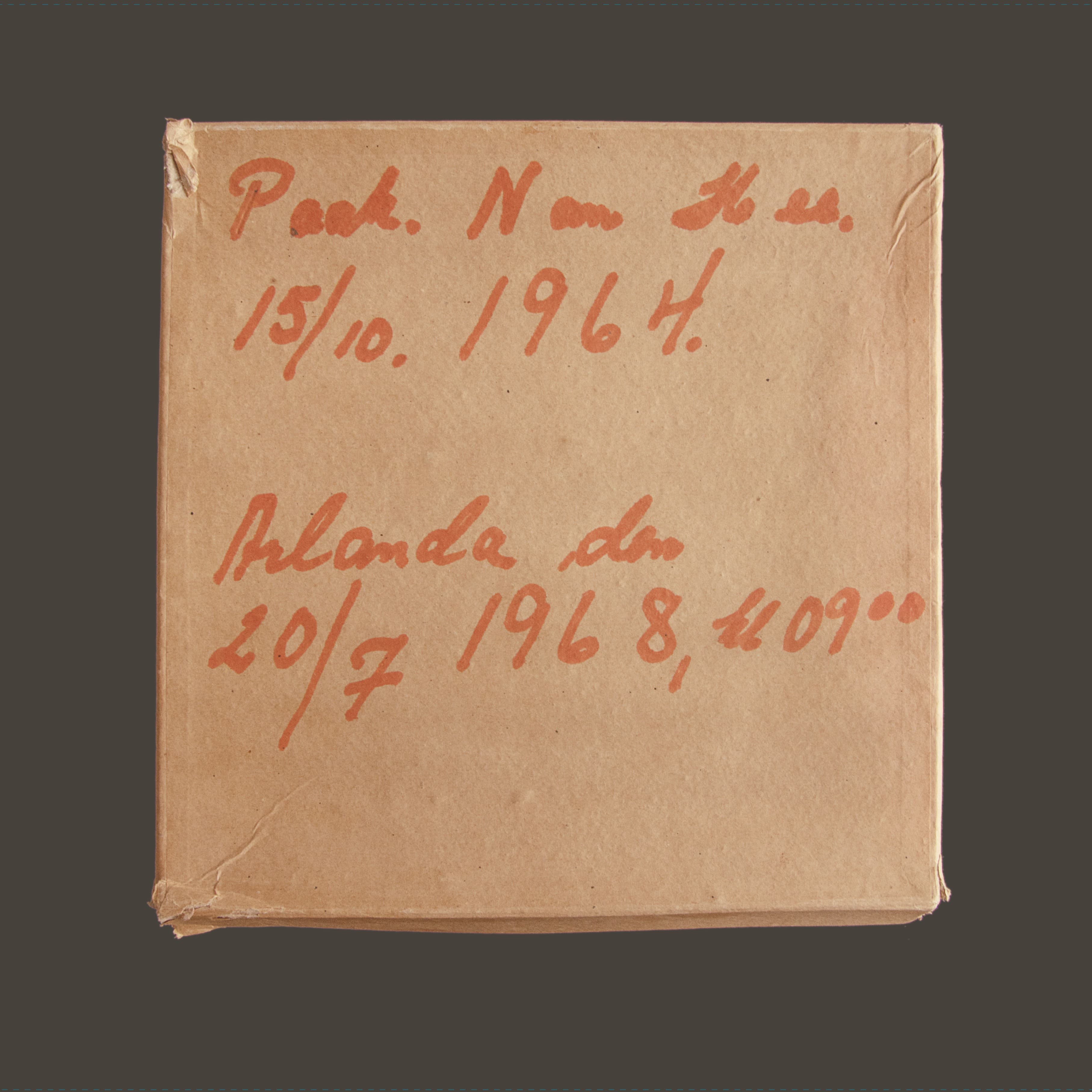 A brown paper package with handwritten text, including dates 15/10/1964 and 20/7/1968.