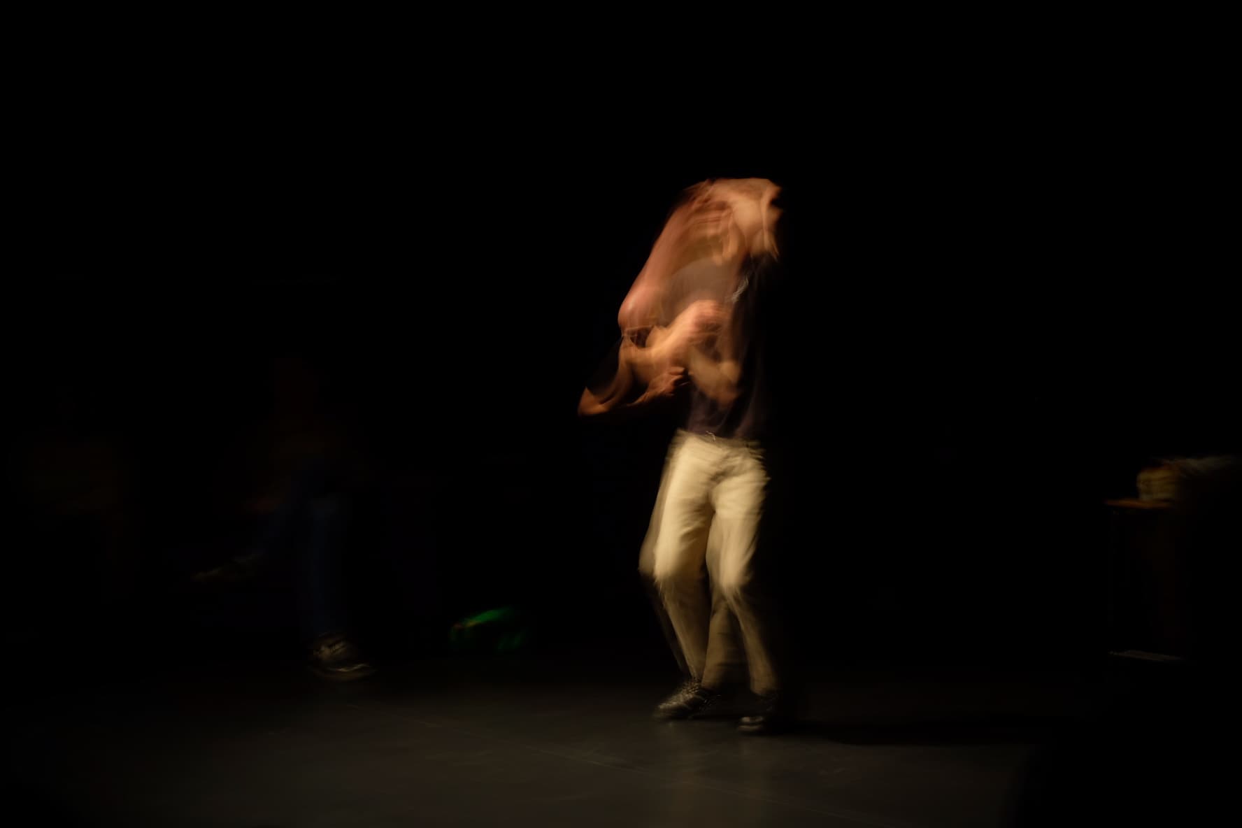 A person is captured in motion blur against a dark background, creating an abstract effect.