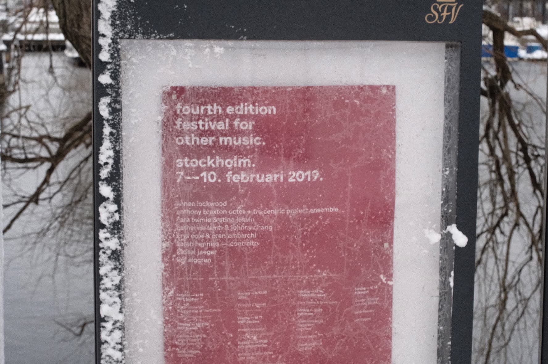 A snow-dusted sign displays a poster for the fourth edition of the Festival for Other Music in Stockholm, dated 7-10 February 2019.